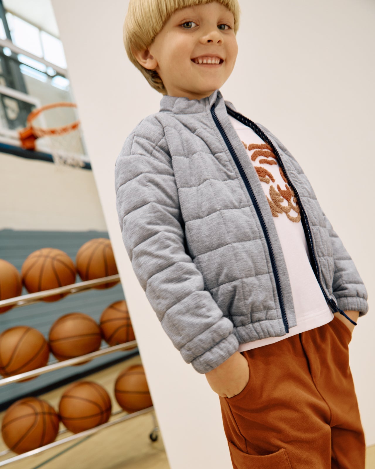 Boy wearing the Heather Gray Quilted Track Jacket in a gymnasium
