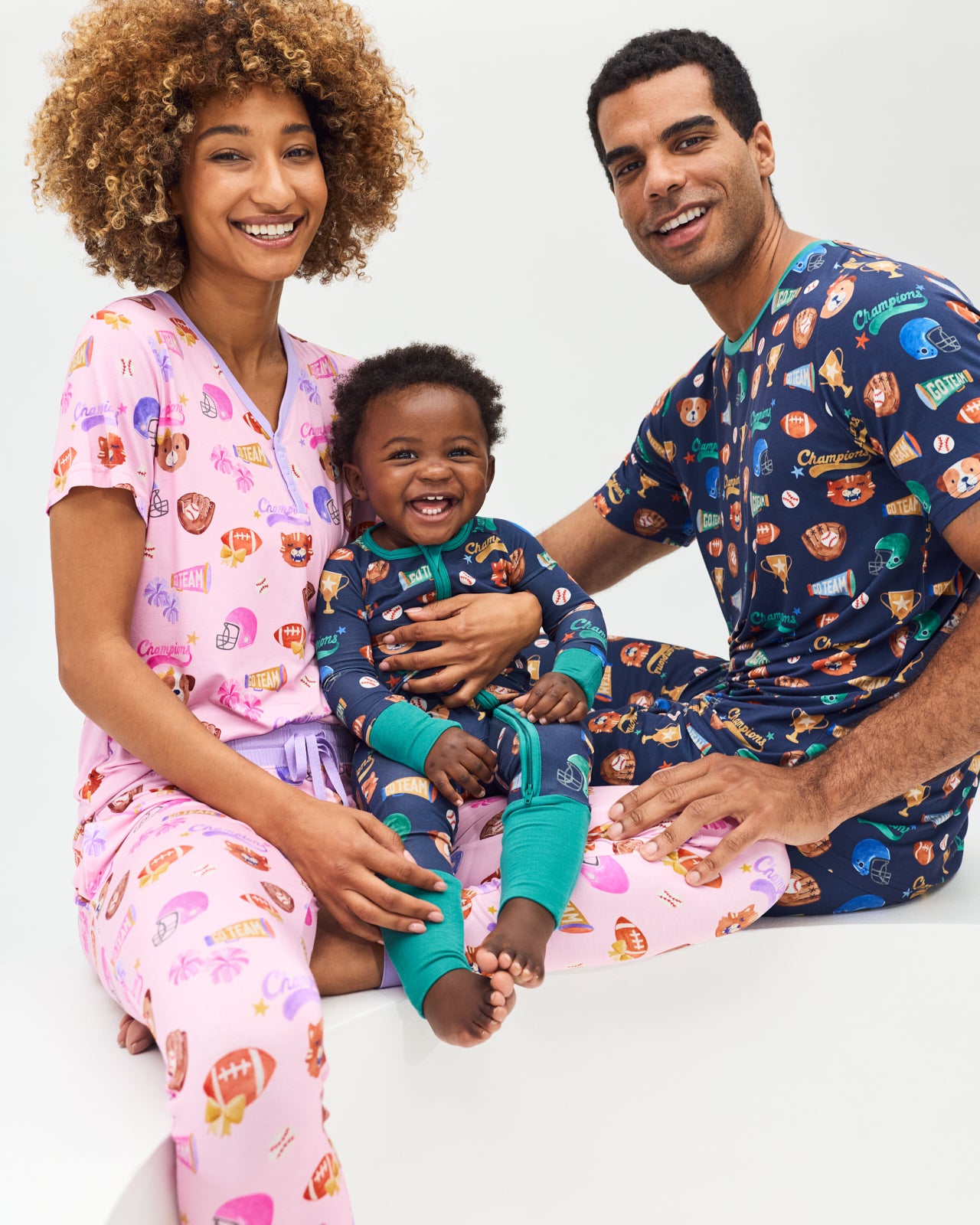 Family of three wearing matching Team Spirit Varsity Themed Pajamas