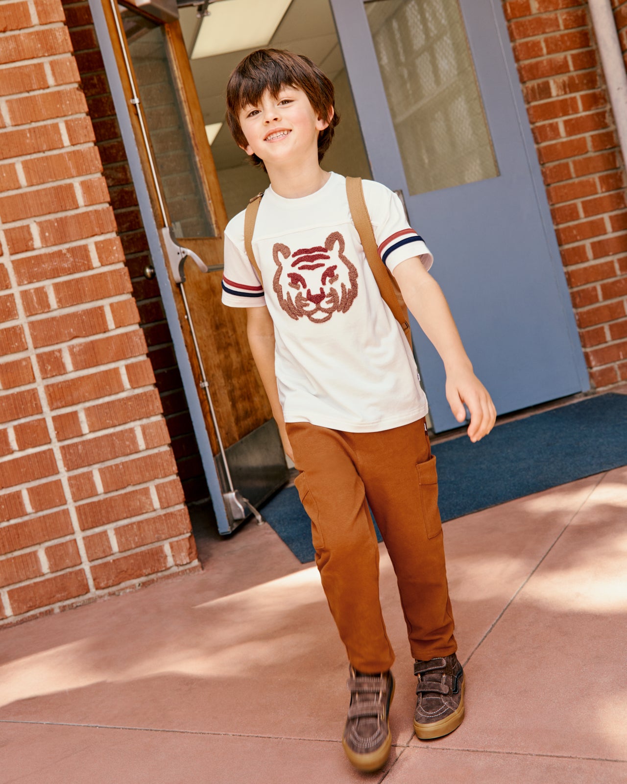 Boy wearing the Amber Oak Cargo Pants and Tiger Tee at a school