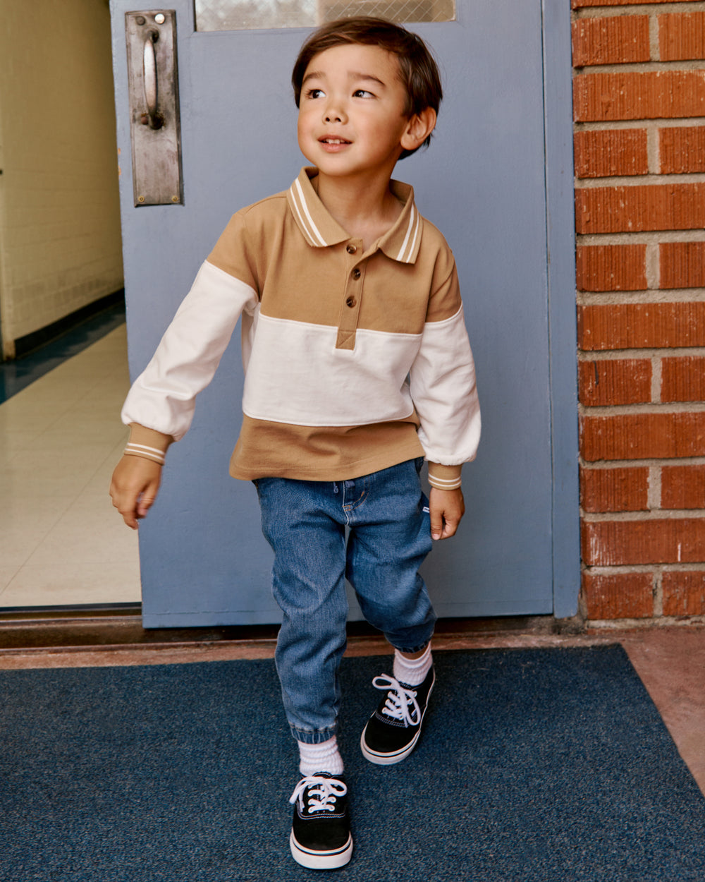 Boy wearing the Maple Cream Rugby Shirt with denim joggers