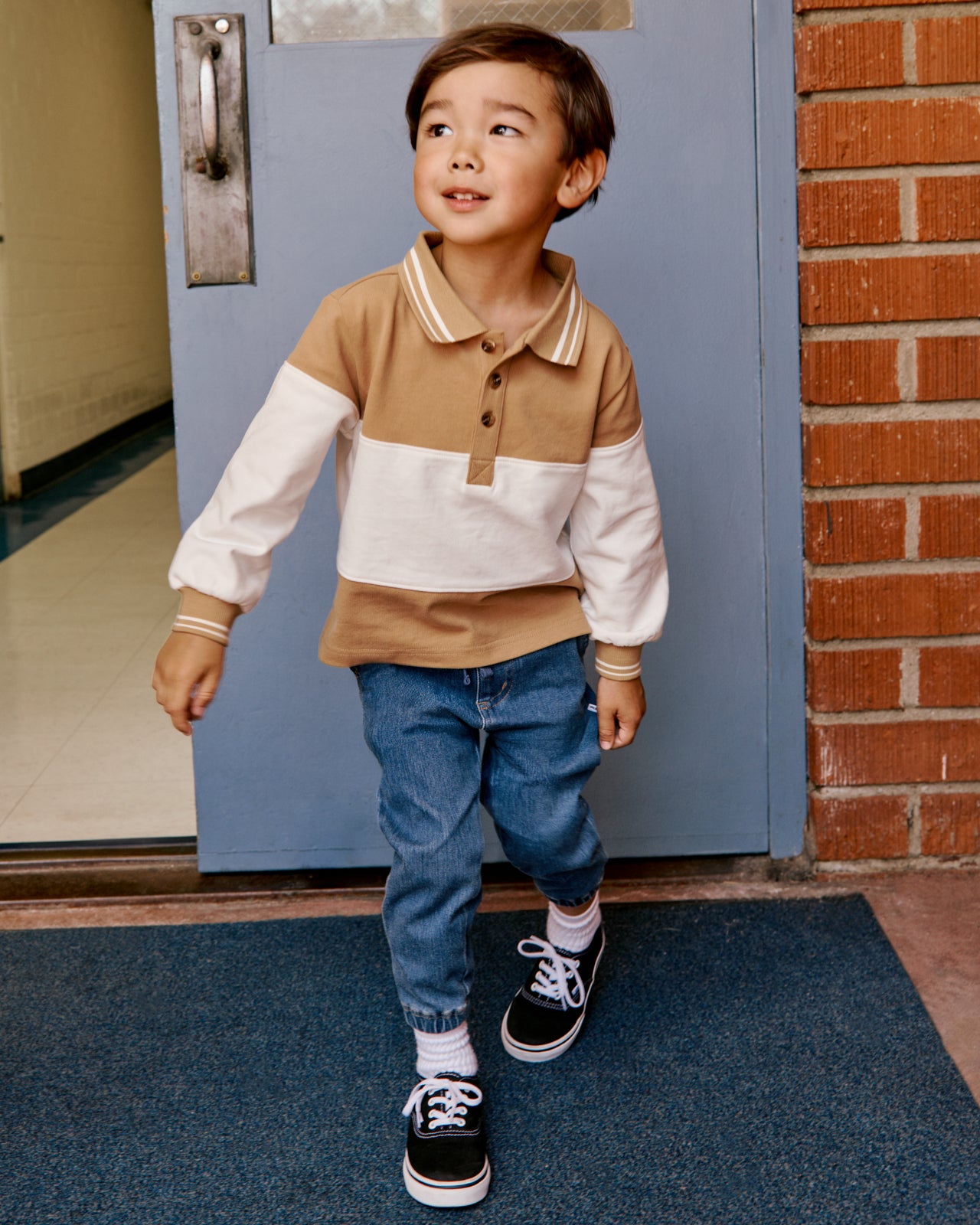 Boy wearing the Maple Cream Rugby Shirt with denim joggers