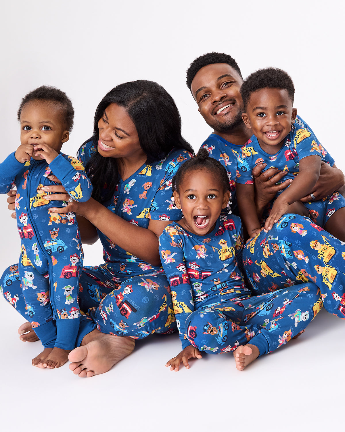 Family of five wearing matching PAW Patrol Adventure Bay Heroes Pajamas