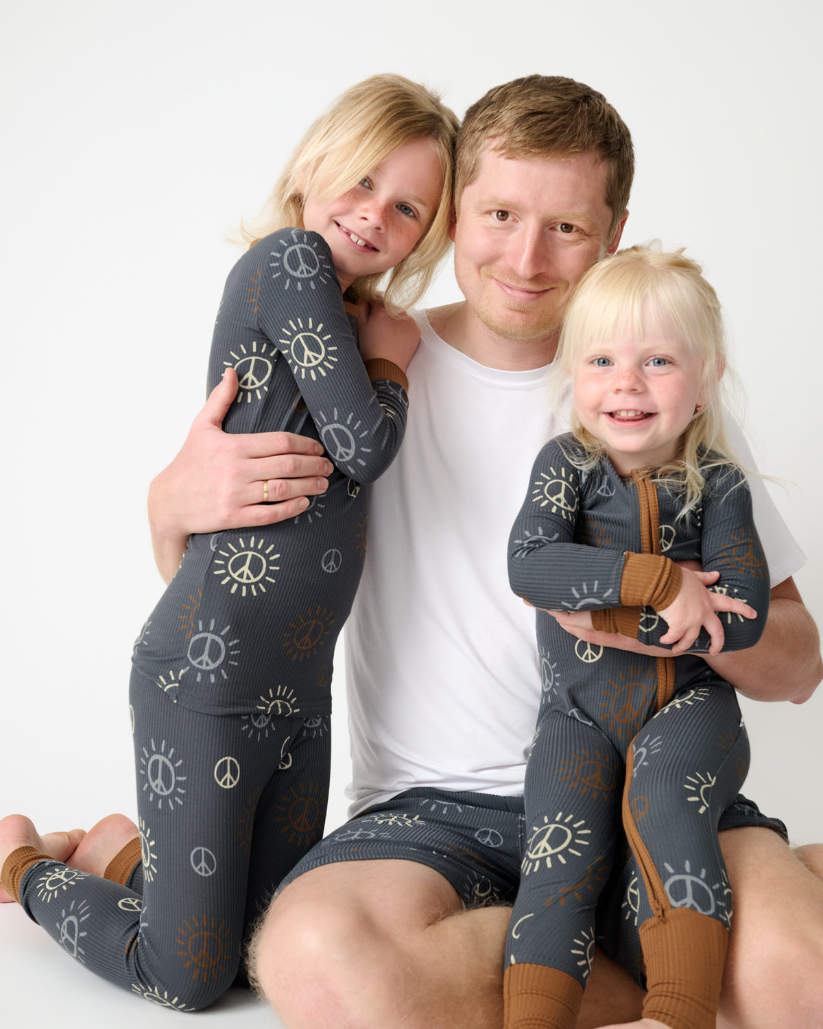Father and two children wearing matching Peace & Love Ribbed PJs