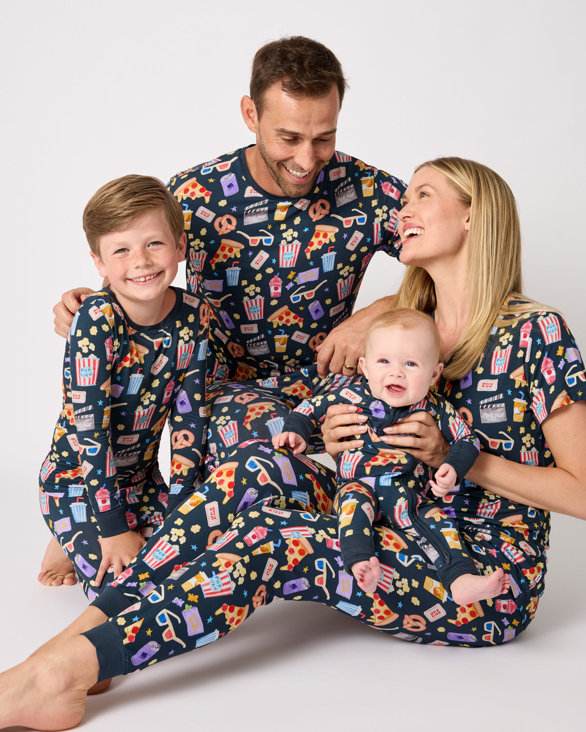 Family of four wearing matching Movie Marathon cinema themed pajamas