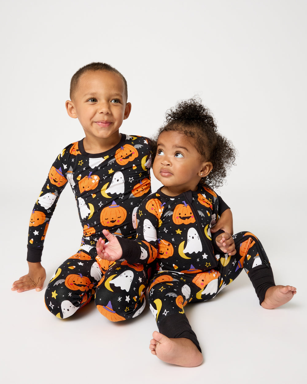 Two children wearing matching Moonlit Magic Halloween Pajamas