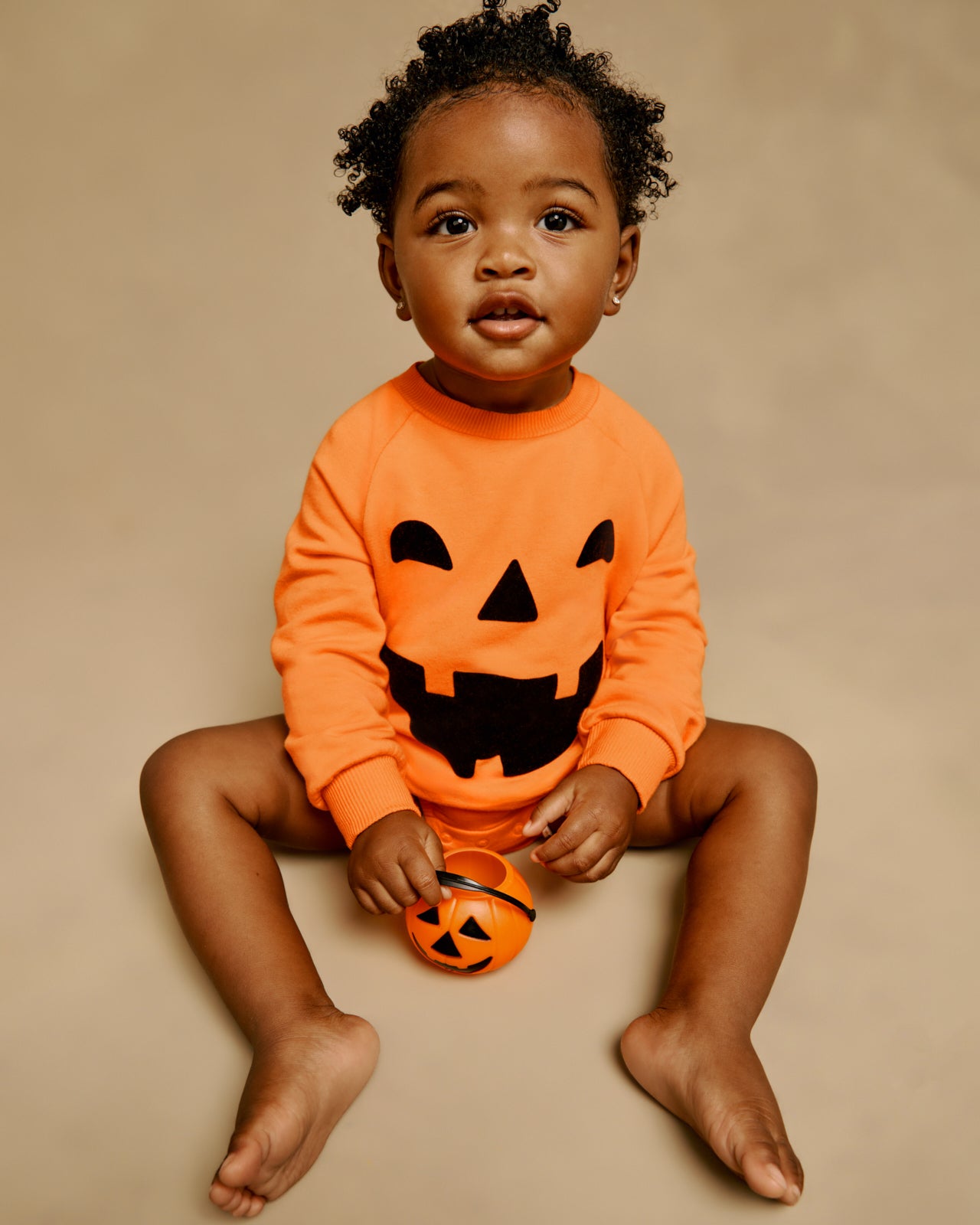Sitting baby wearing the Jack-O'-Lantern Raglan Romper