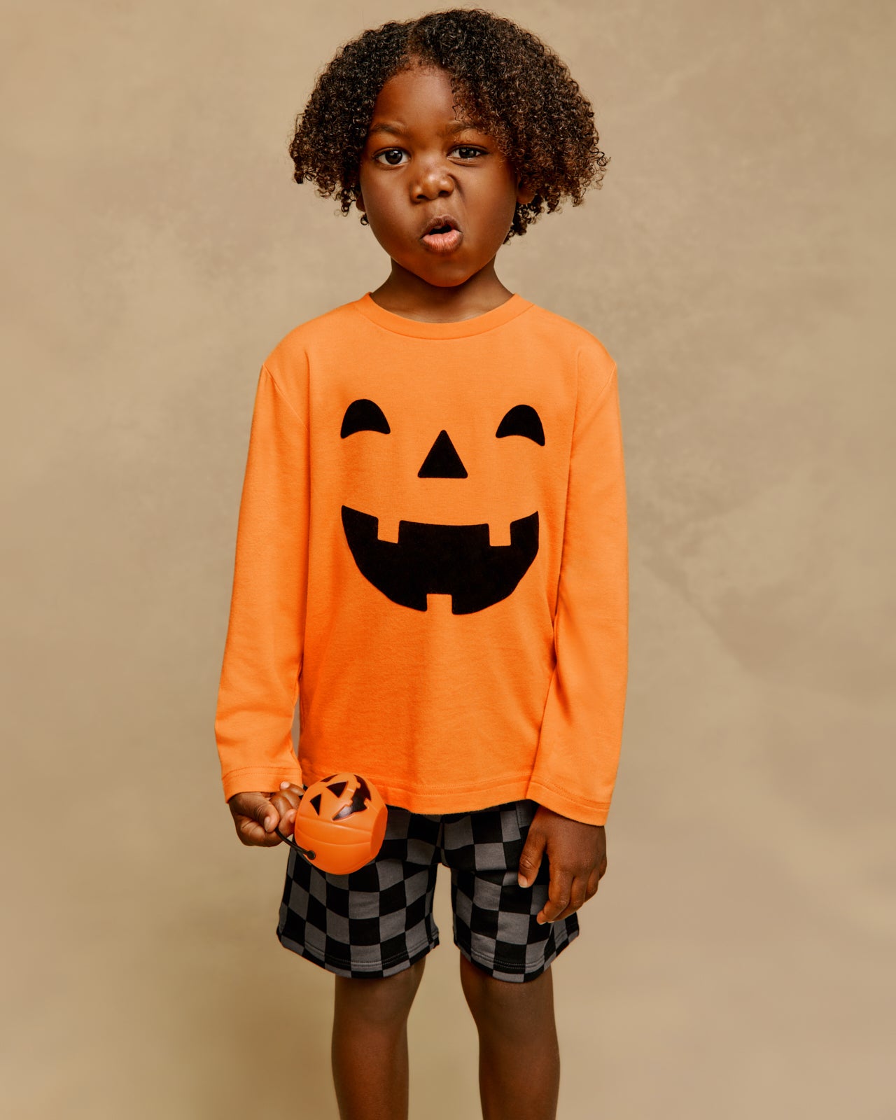 Boy wearing the Jack-O'-Lantern Long Sleeve Relaxed Tee with checkered shorts