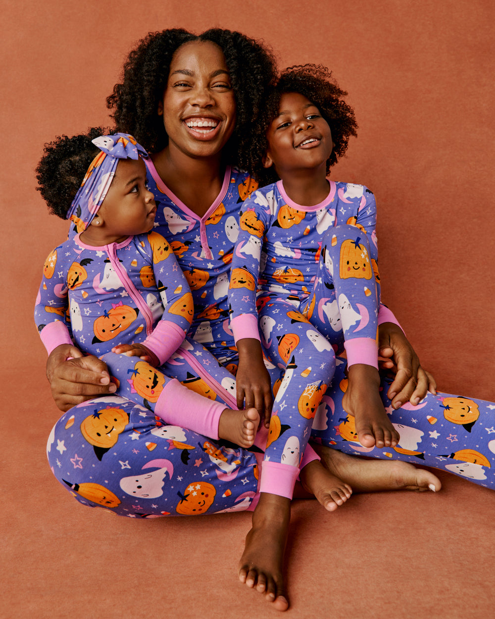 Mother and two children wearing matching Moonlit Magic Purple Pajamas