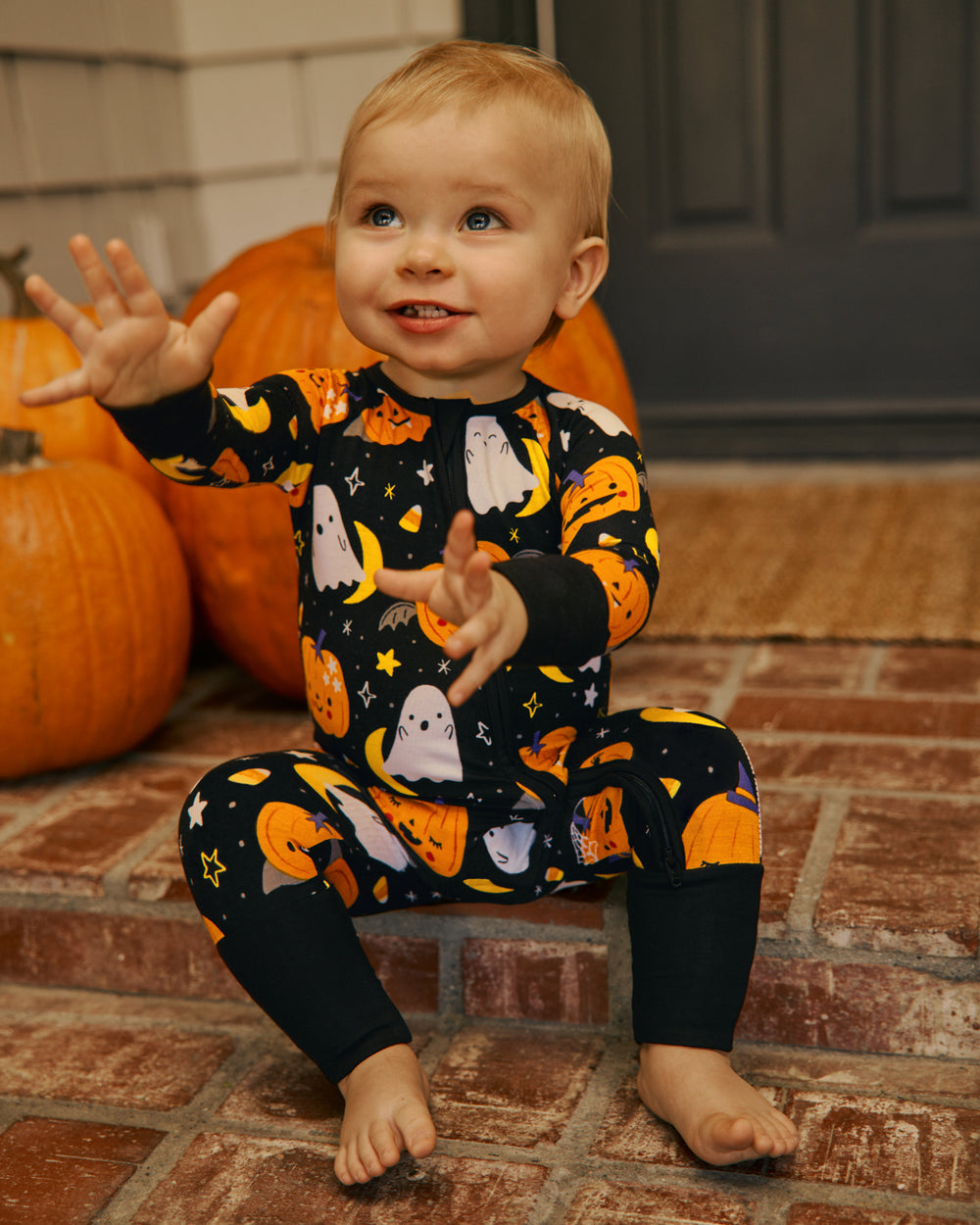 Baby sitting on a stoop wearing the Moonlit Magic Zippy