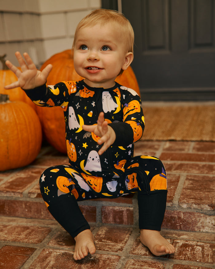 Baby sitting on a stoop wearing the Moonlit Magic Zippy