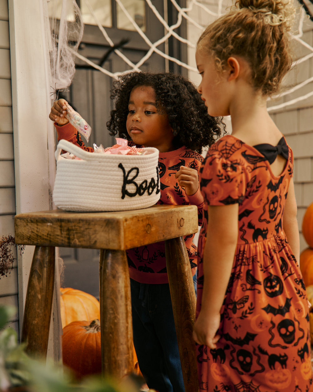 Two children wearing Midnight Mischief play styles going trick or treating