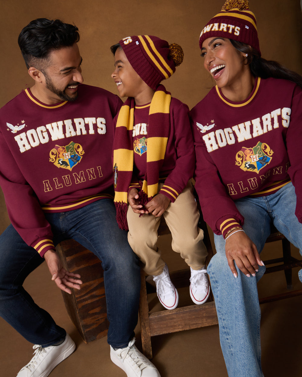 Family of three wearing matching Harry Potter™ Spellbinding Studies Crewneck Sweatshirts