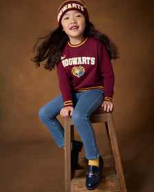 Girl wearing the Harry Potter™ Spellbinding Studies Crewneck Sweatshirt with denim jeggings