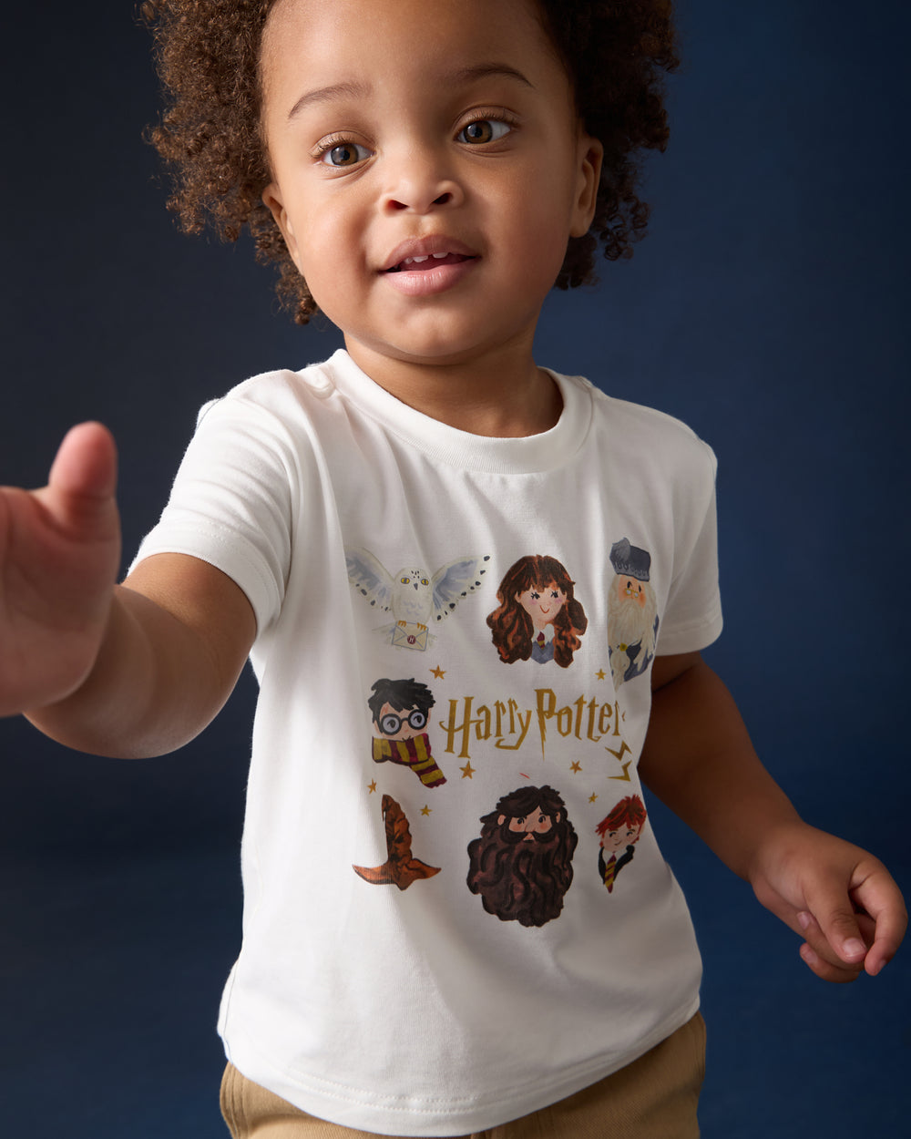 Boy wearing the Harry Potter™ Spellbinding Studies Relaxed Tee on a blue back drop