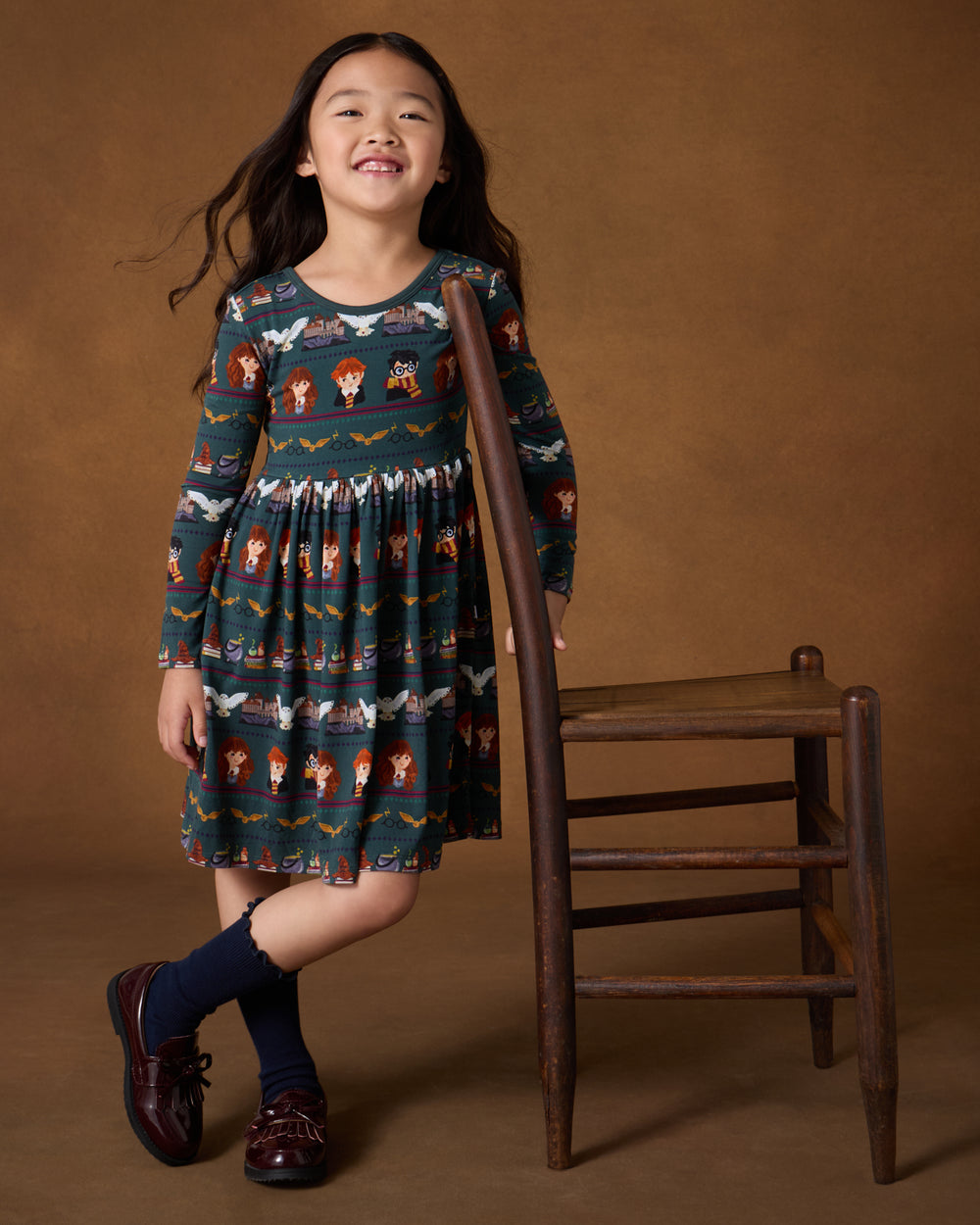 Girl wearing the Harry Potter™ Spellbinding Studies Skater Dress with leather loafers
