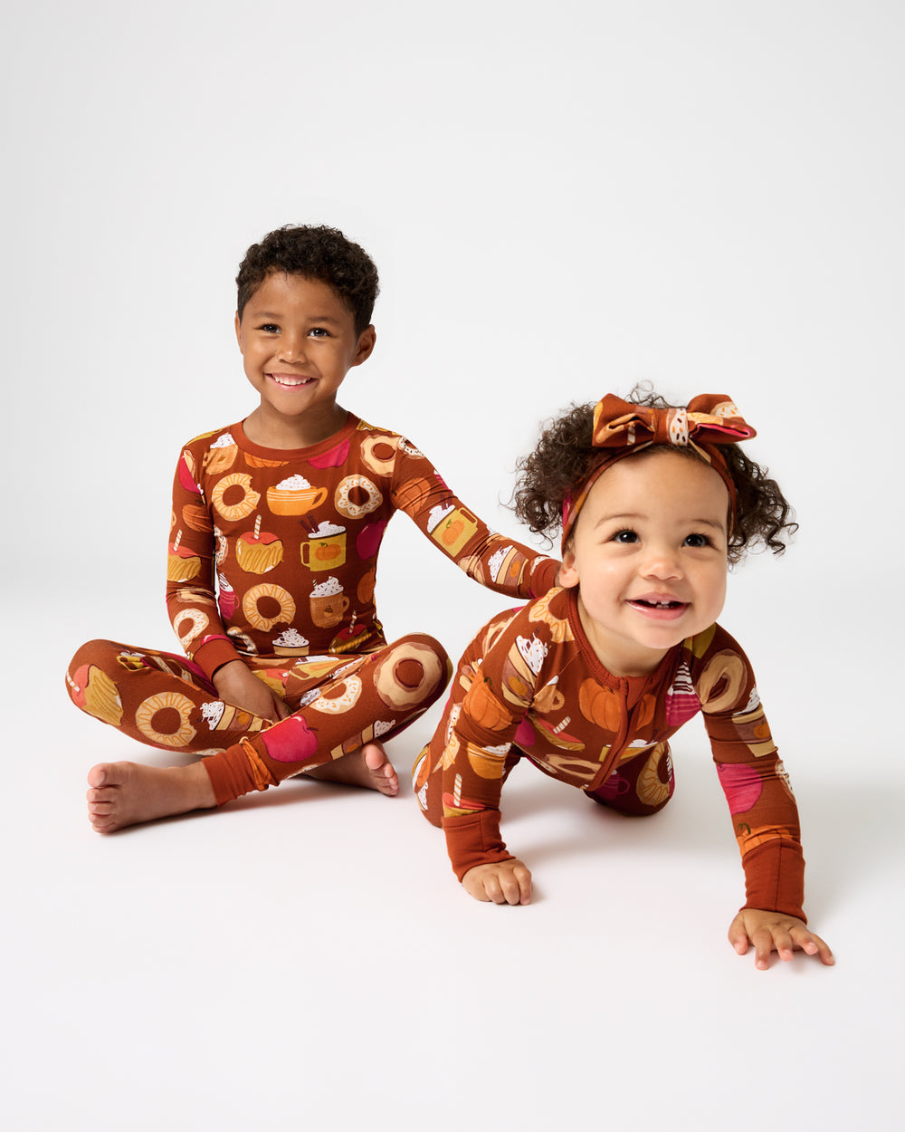 Two children wearing matching Harvest Sweets pajamas