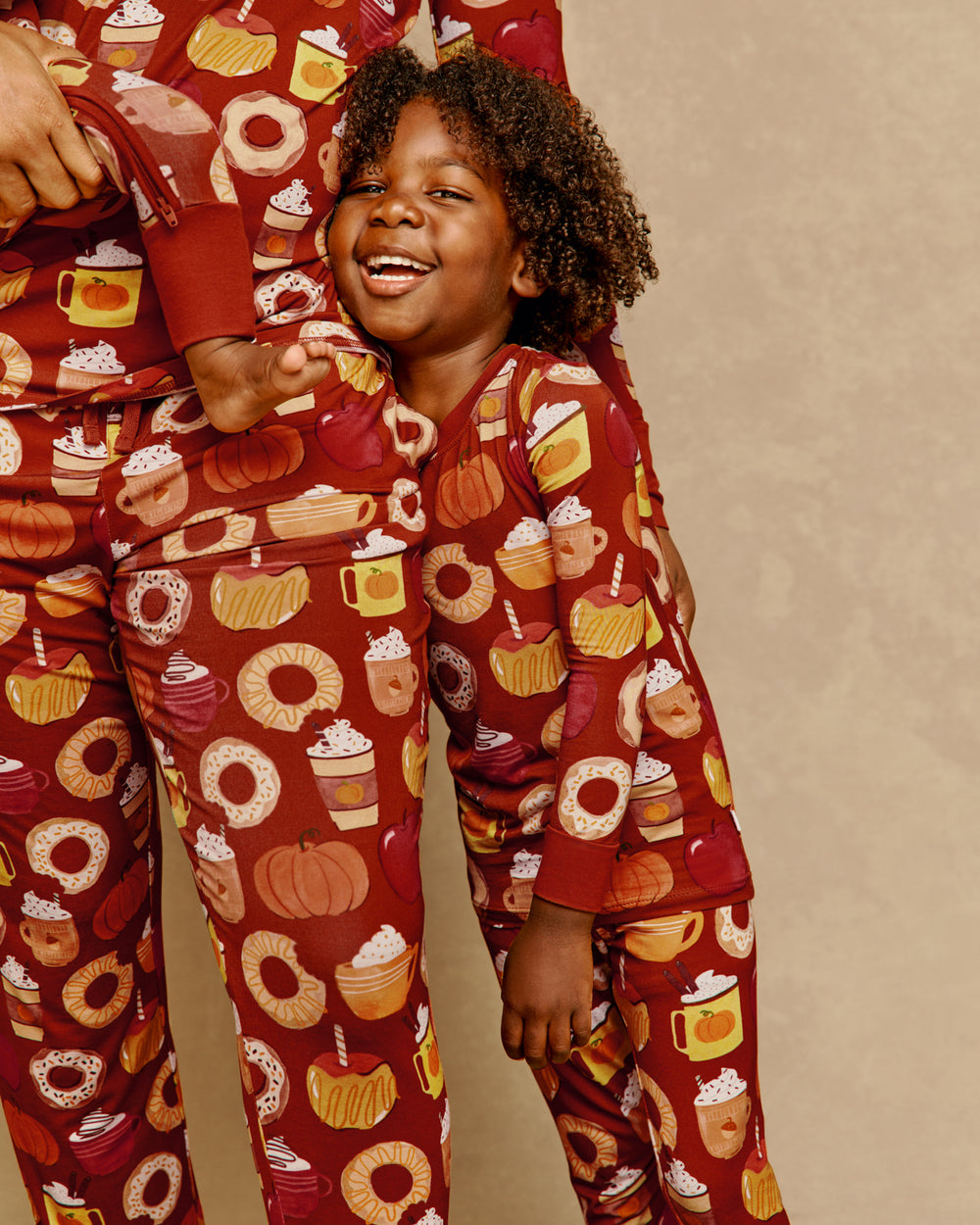 Close up of boy wearing the Harvest Sweets Two-Piece Pajama Set leaning on moms leg