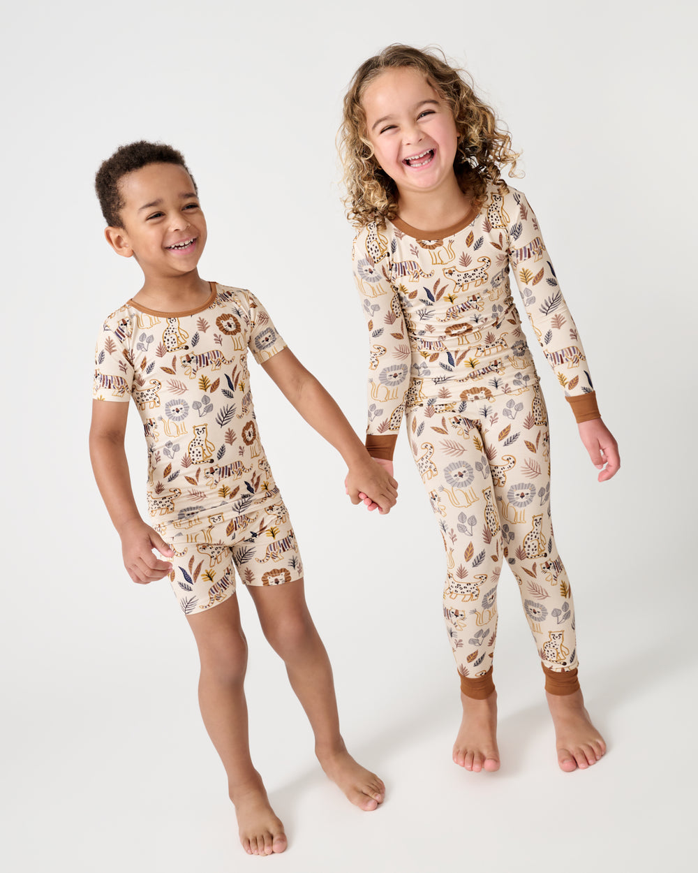 Two children wearing matching Savanna Friends Two-Piece Pajama Sets