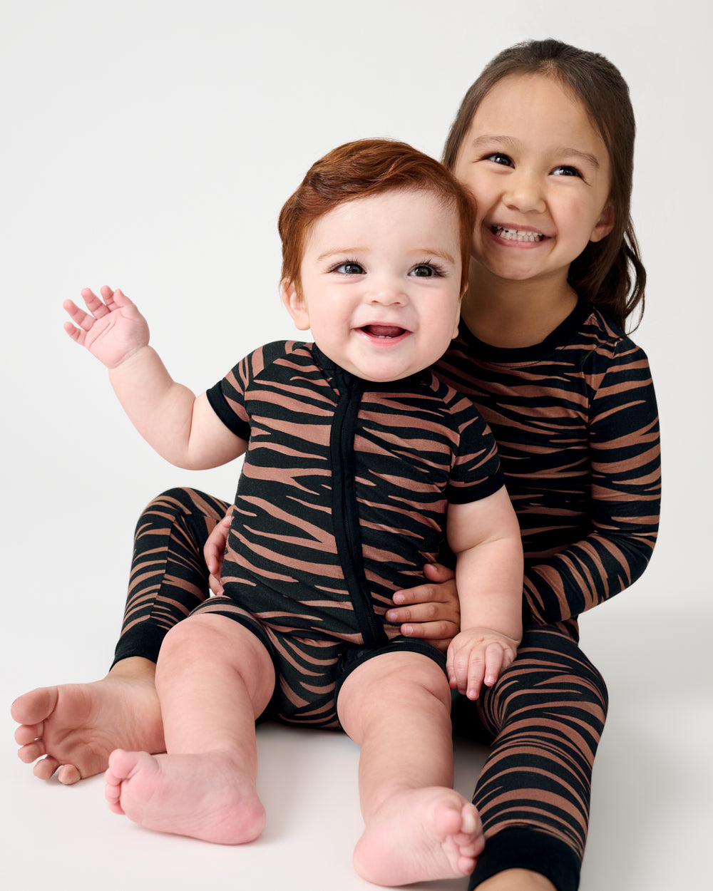 Two children wearing matching Wild Stripes Shorty Zippy
