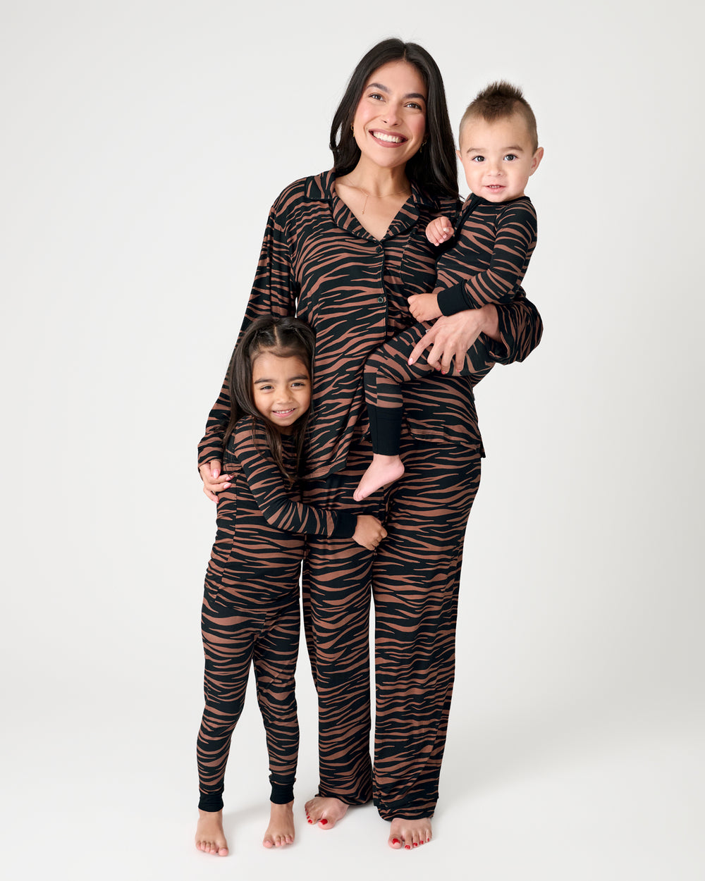 Family of three wearing matching Wild Stripes Pajamas
