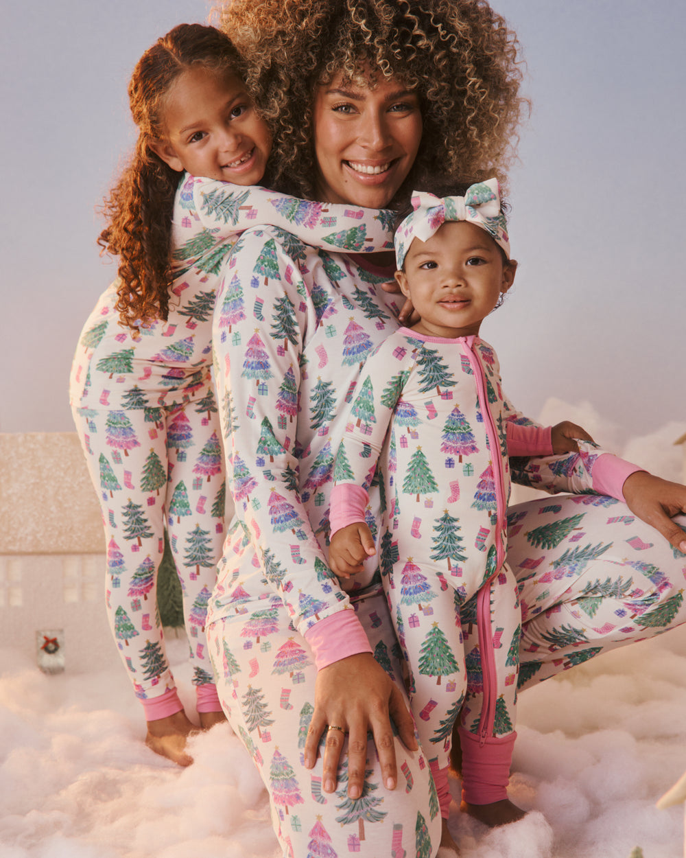 Mother and two children wearing matching Joyful Traditions Pink PJs