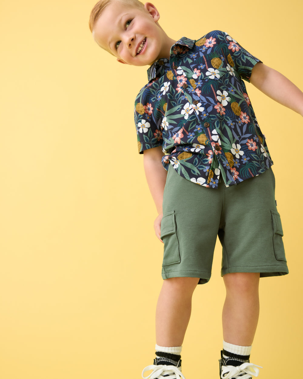 Boy wearing the Tropical Garden Button Down Polo with green cargo shorts