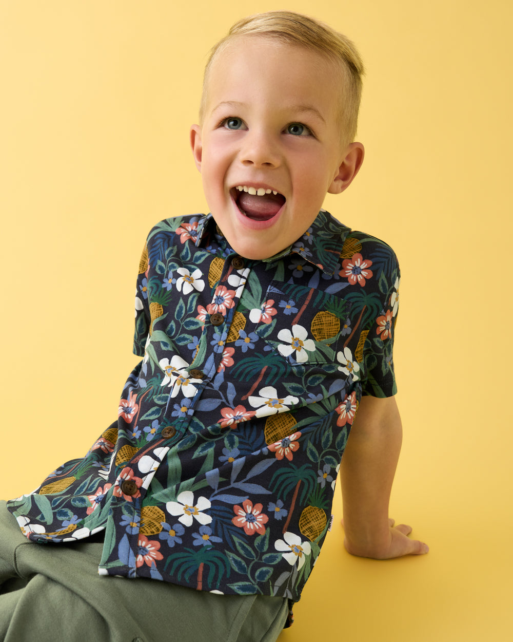 Boy wearing the Tropical Garden Button Down Polo on a yellow backdrop
