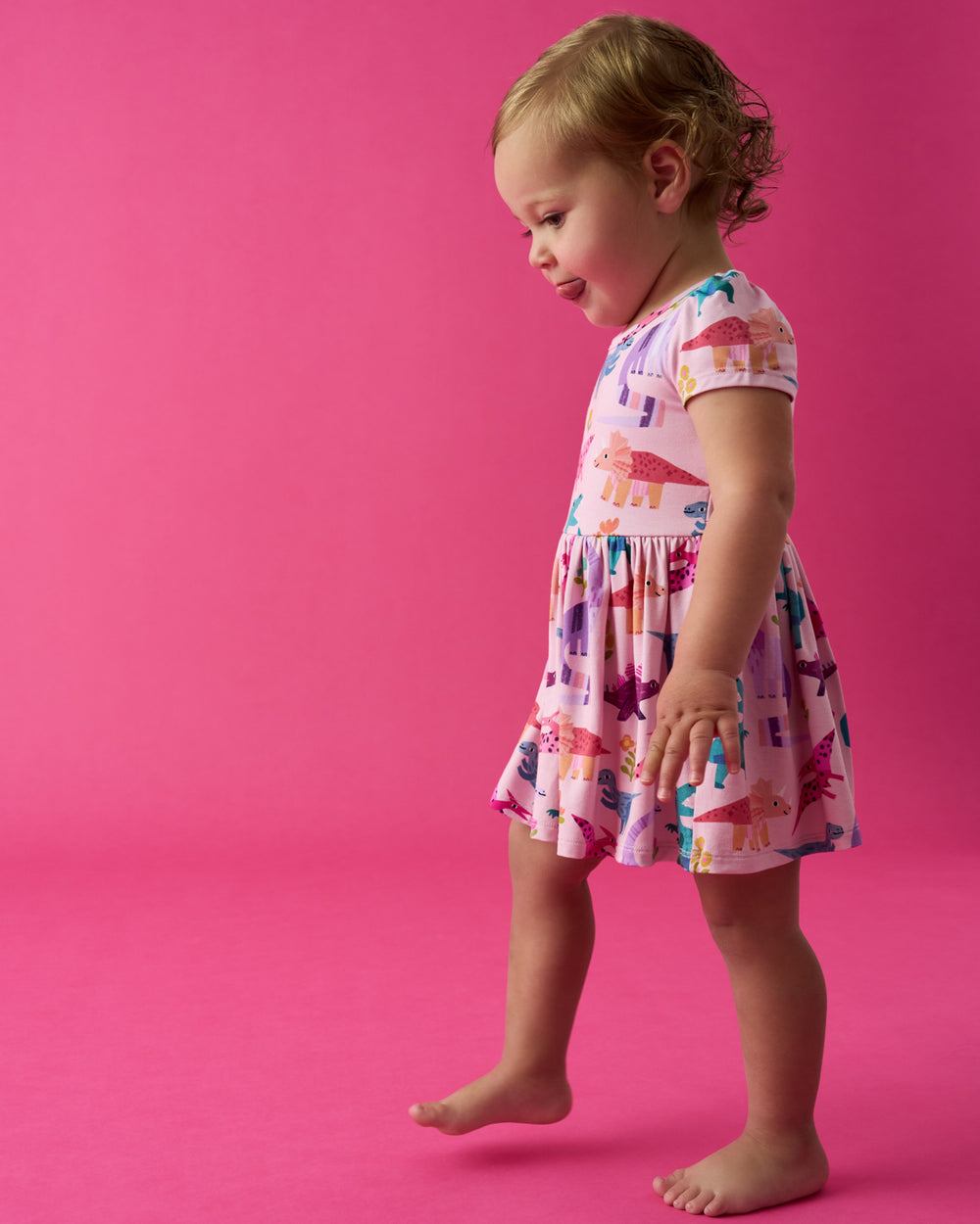 Toddler wearing the Roar & Explore Skater Dress with Bodysuit on a pink back drop