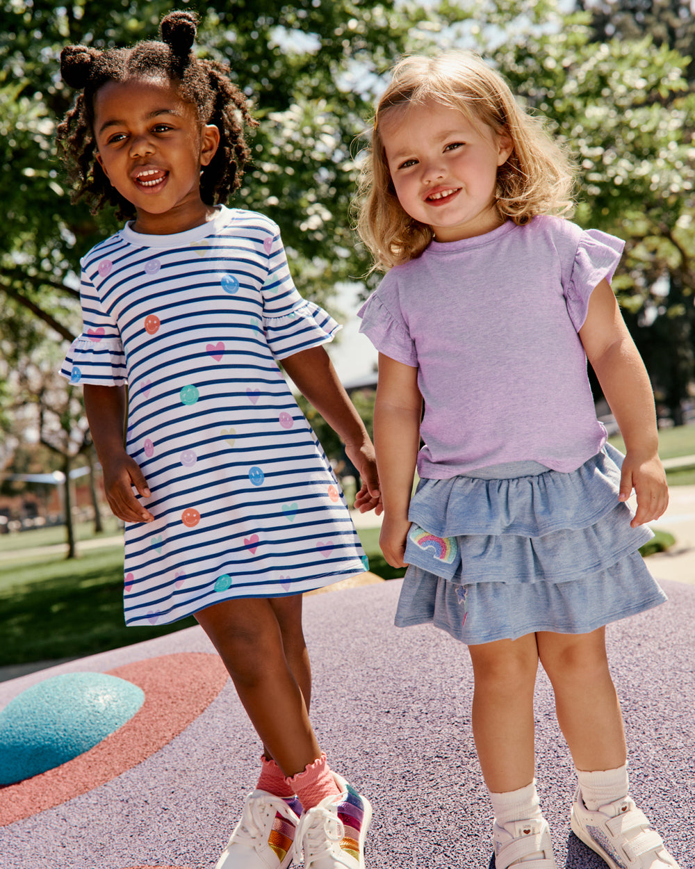 Two girls wearing Back to School daywear styles on a playscape 