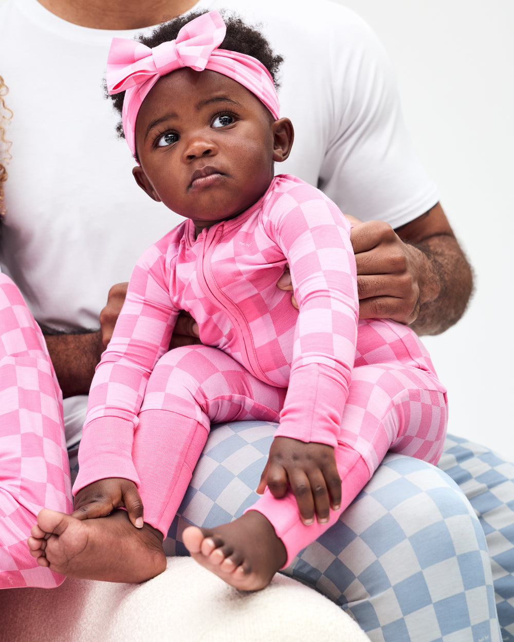 Baby sitting on her Father's lap wearing the Sweet Raspberry Checks Zippy
