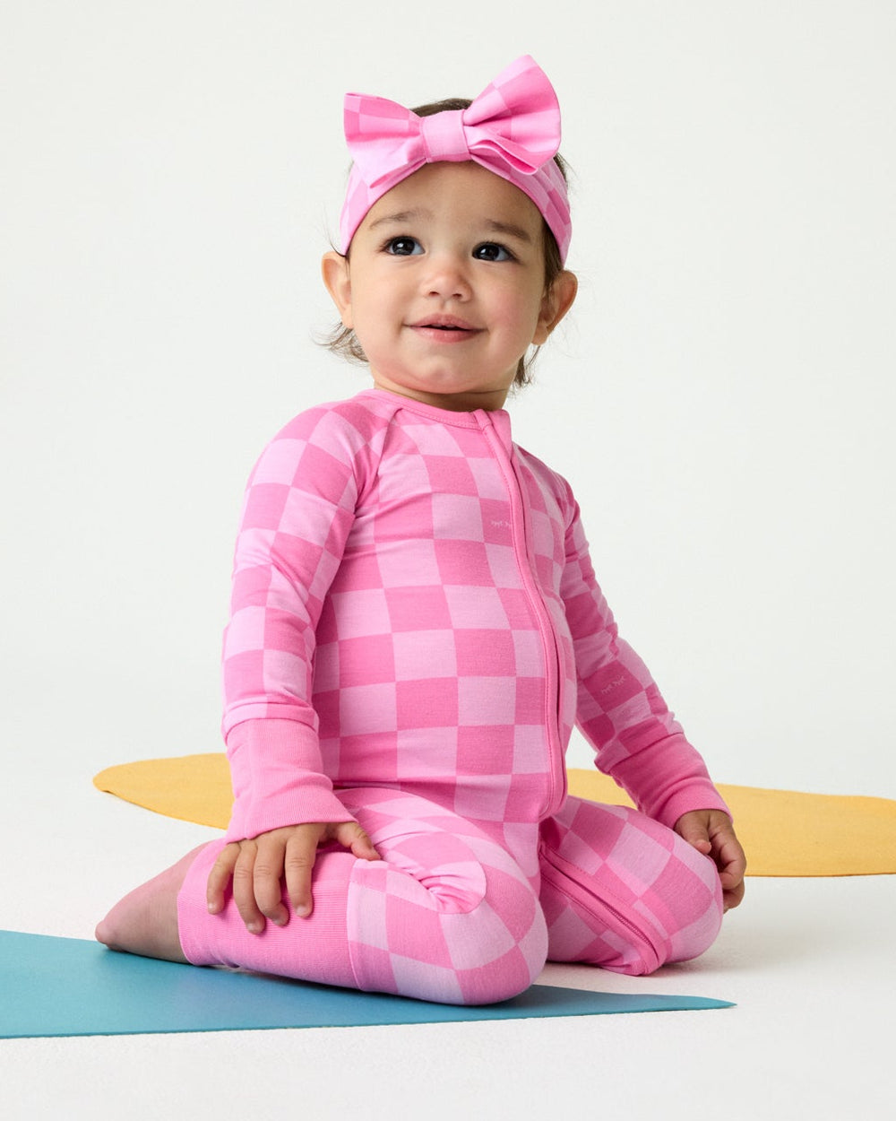 Baby girl wearing the Sweet Raspberry Checks Zippy and Bow Headband