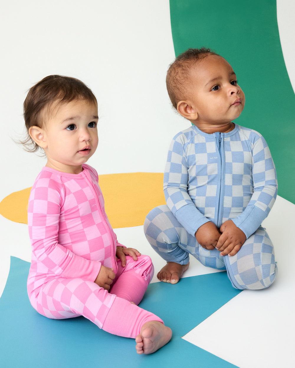 Two babies wearing matching Sweet Raspberry and Dusk Blue Checks Zippys
