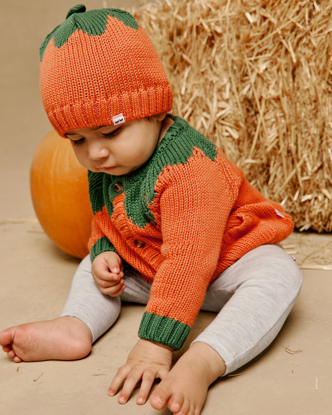 Sitting baby wearing the Pumpkin Sweater Beanie and Cardigan
