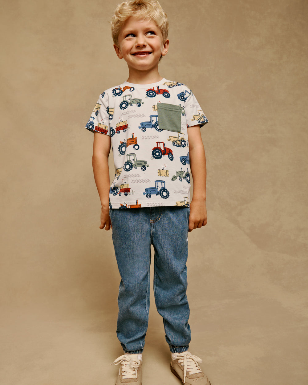 Boy wearing the Tractor Tales Relaxed Pocket Tee with denim joggers