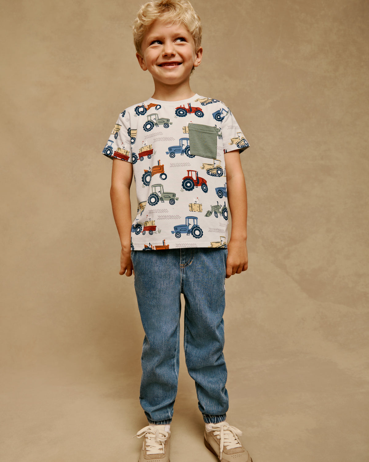 Boy wearing the Tractor Tales Relaxed Pocket Tee with denim joggers