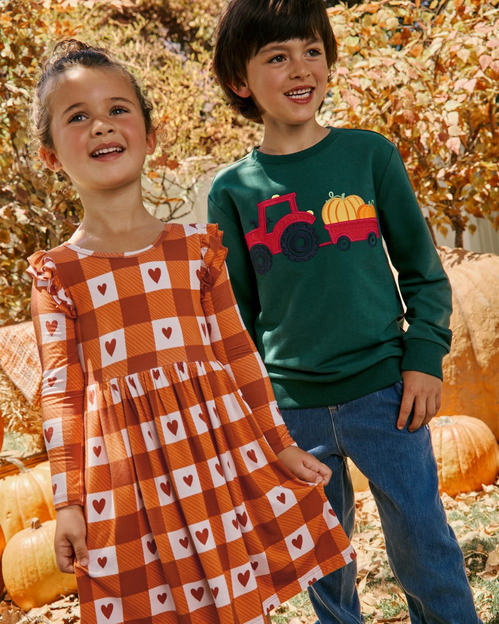 Two children wearing Little Sleepies Fall clothing at a pumpkin patch