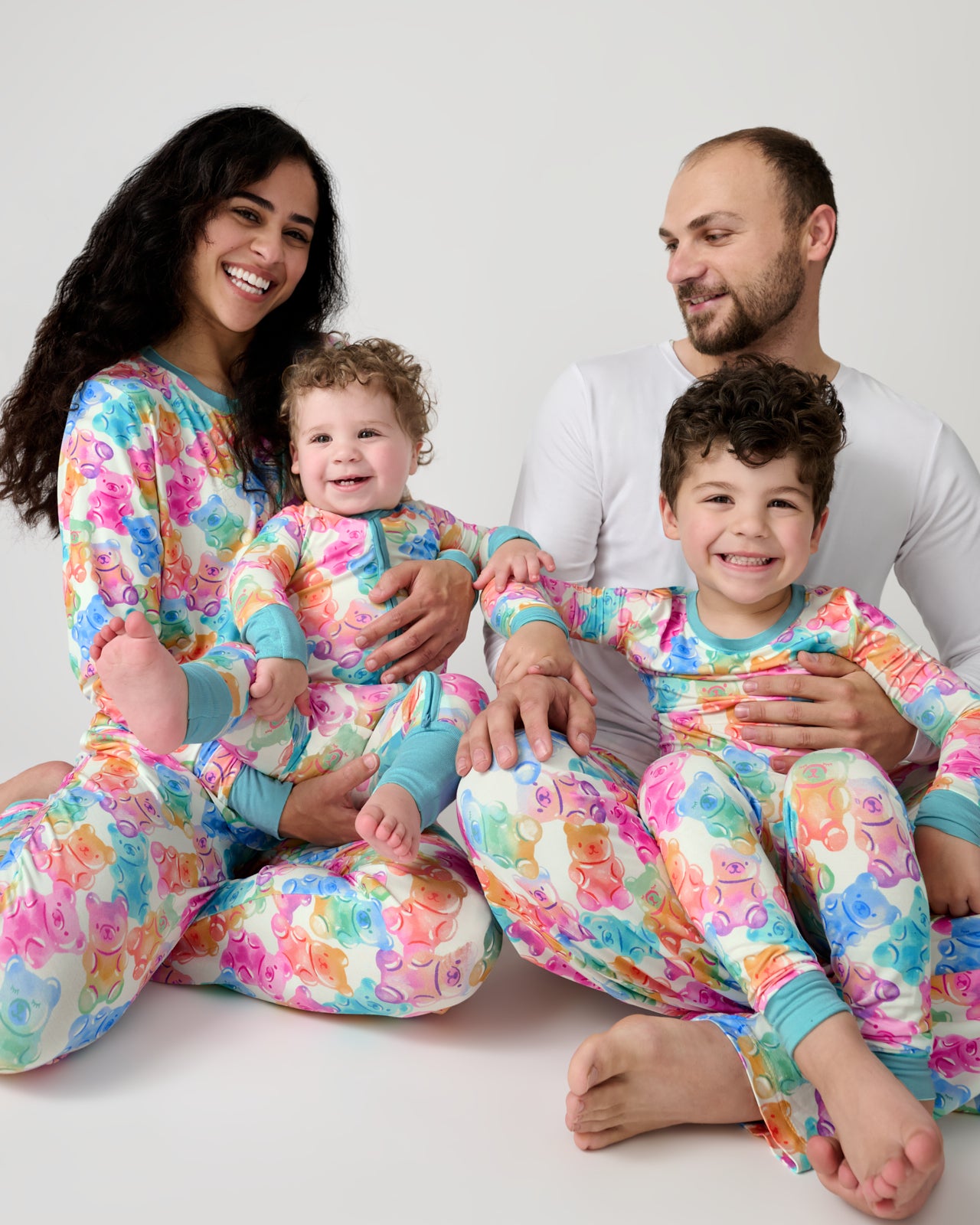 Family of four wearing matching Gummy Giggles Pajamas