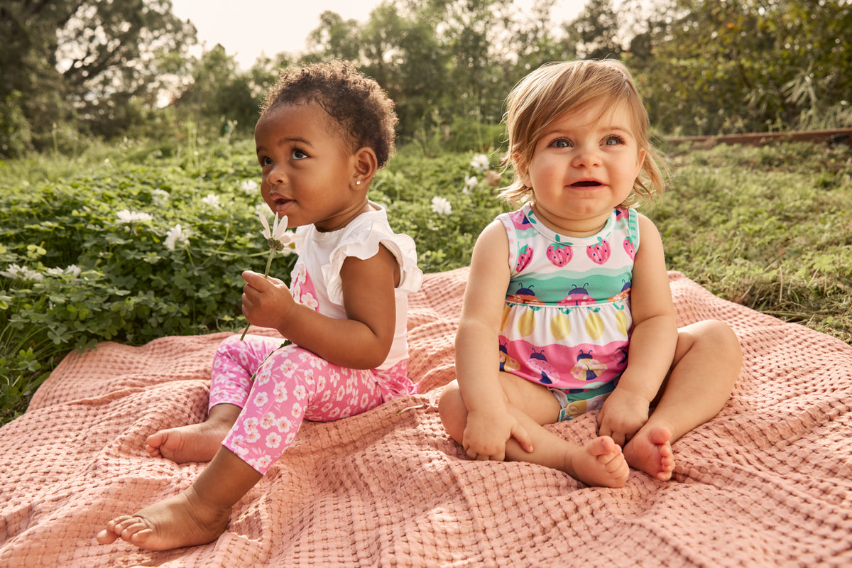 Two babies wearing styles from the Spring Play Capsule