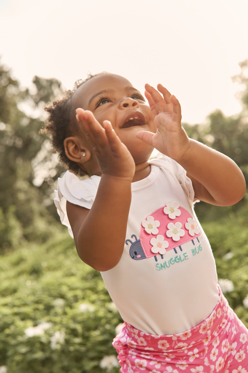 Clapping baby wearing the Snuggle Bug Flutter Bodysuit