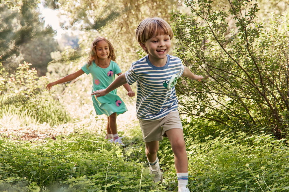 Child running in a wooded area wearing the Zippy Turtle Relaxed Pocket Tee