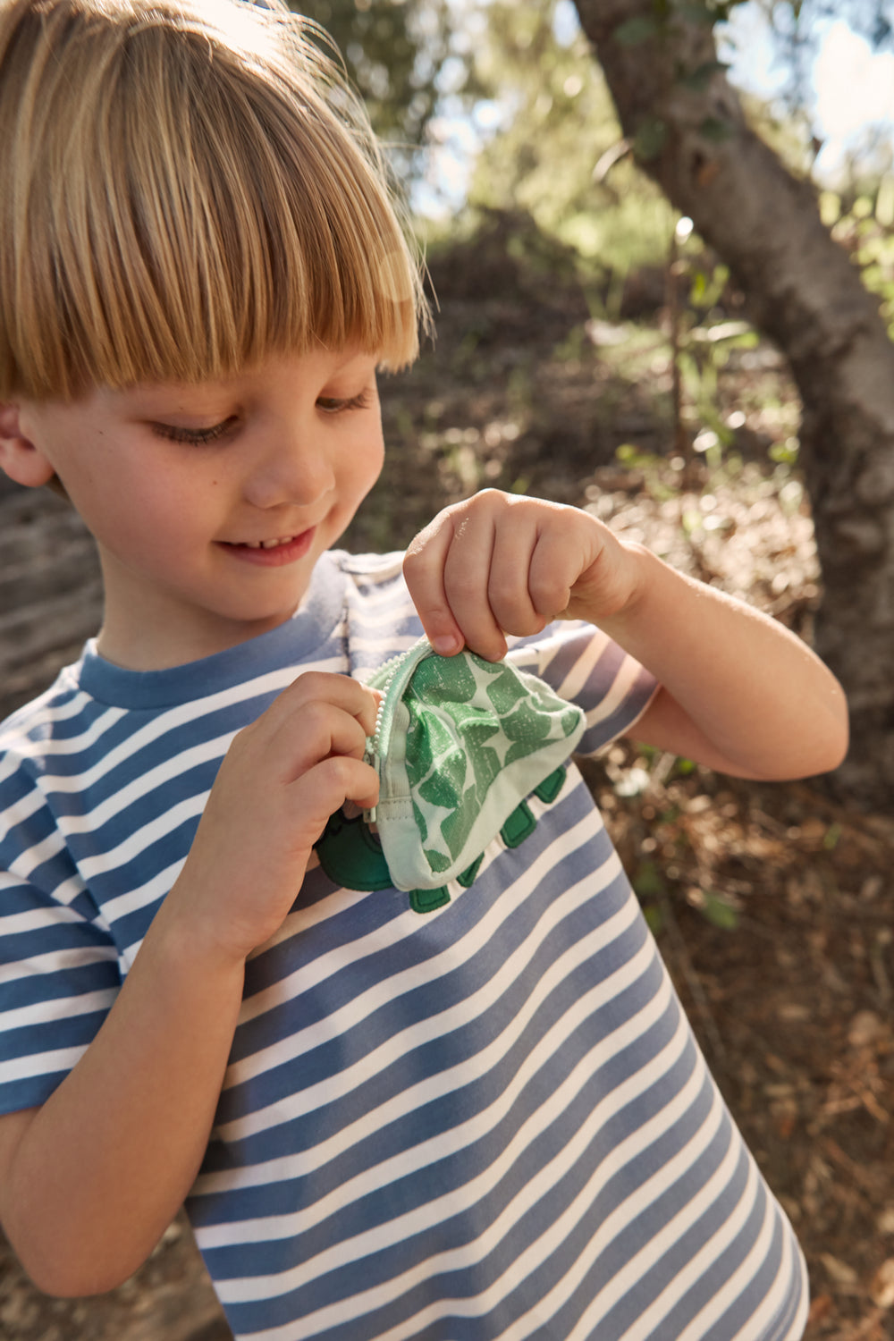 Boy looking in the pocket detail on the Zippy Turtle Relaxed Pocket Tee