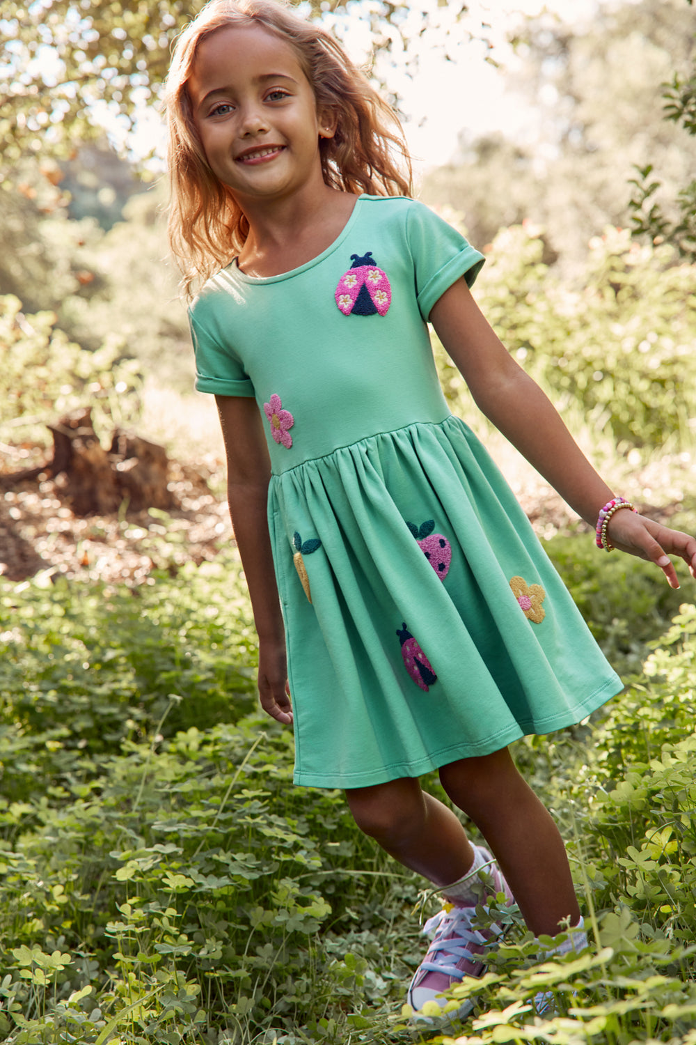 Girl wearing the Garden Party Pocket Dress with a grassy background