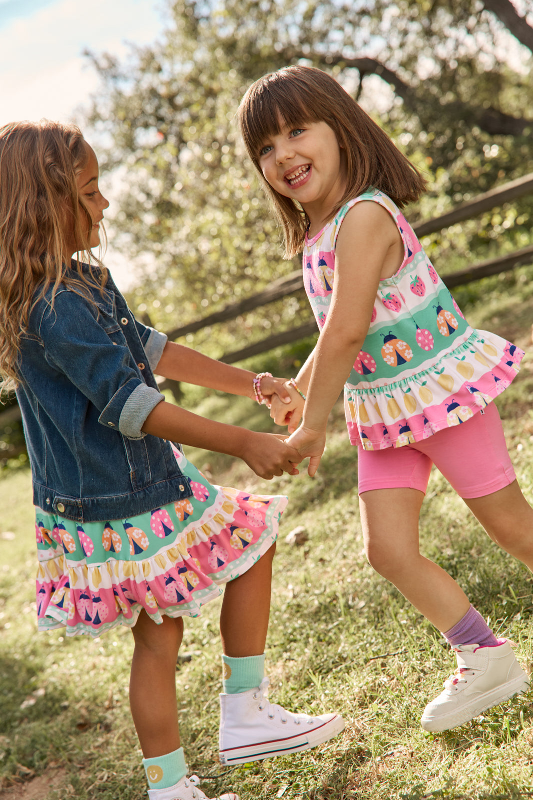 Two girls wearing Ladybug Lane print styles from the Spring Play Capsule 