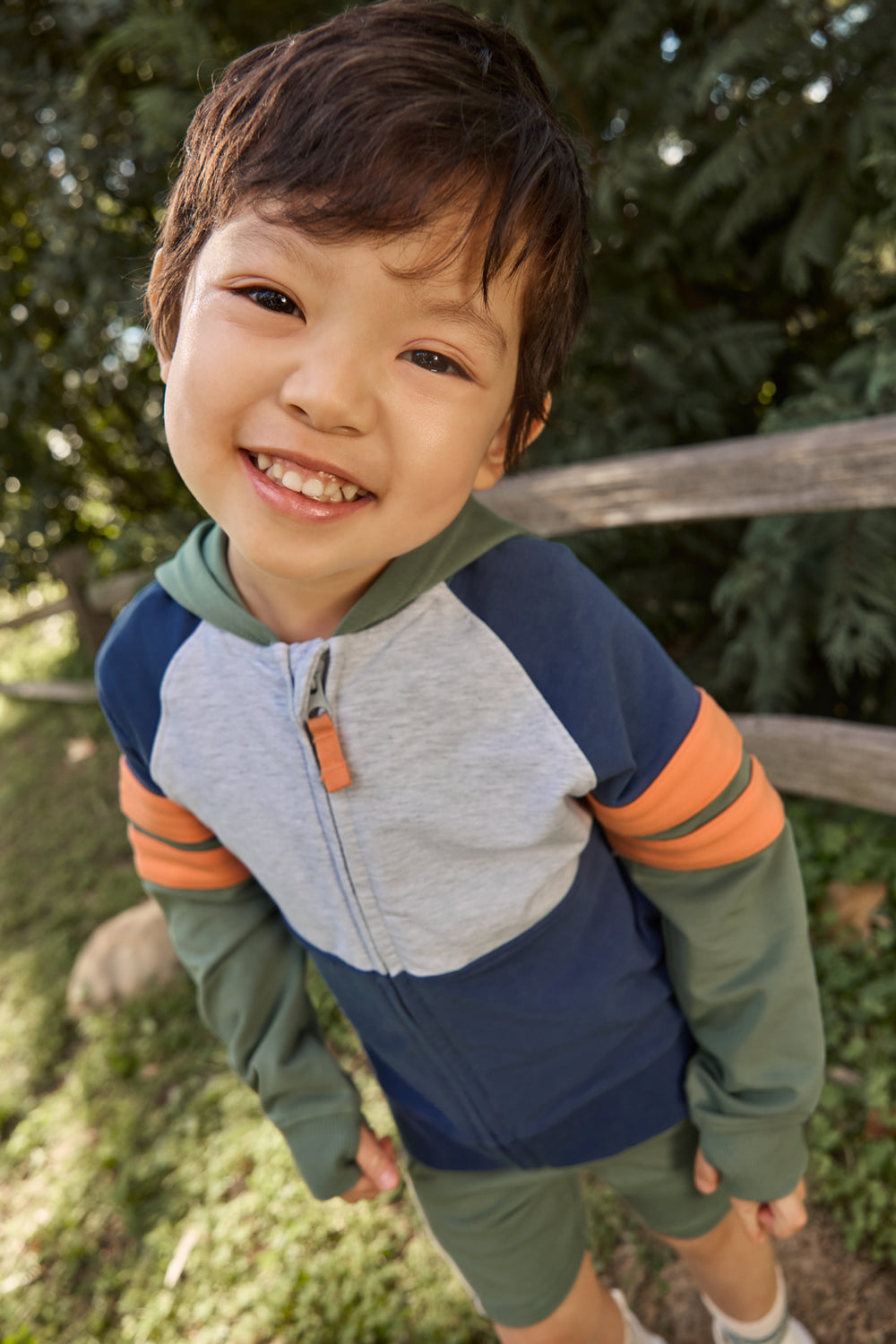 Boy wearing the Moss Colorblock Zip Hoodie with a grassy background