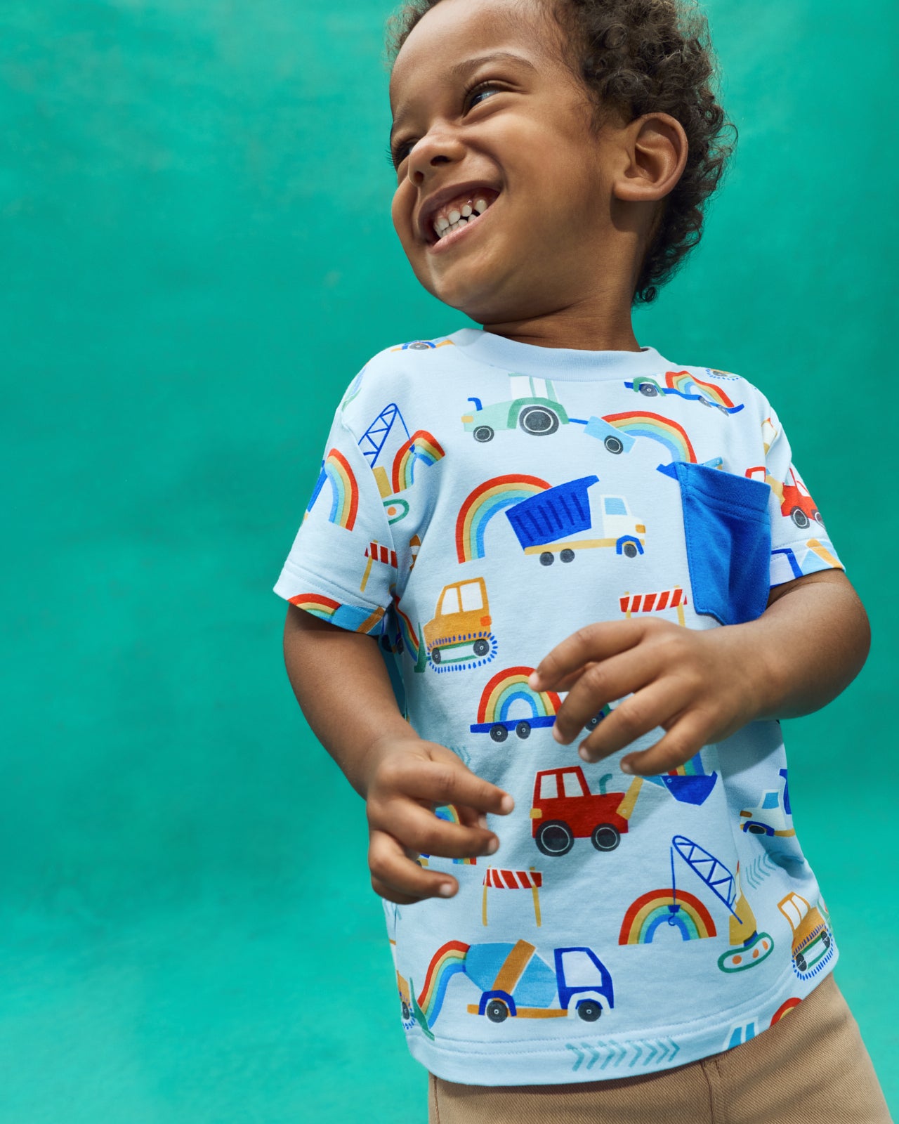 Flat lay of the Rainbow Trucks Relaxed Pocket Tee on a teal back drop