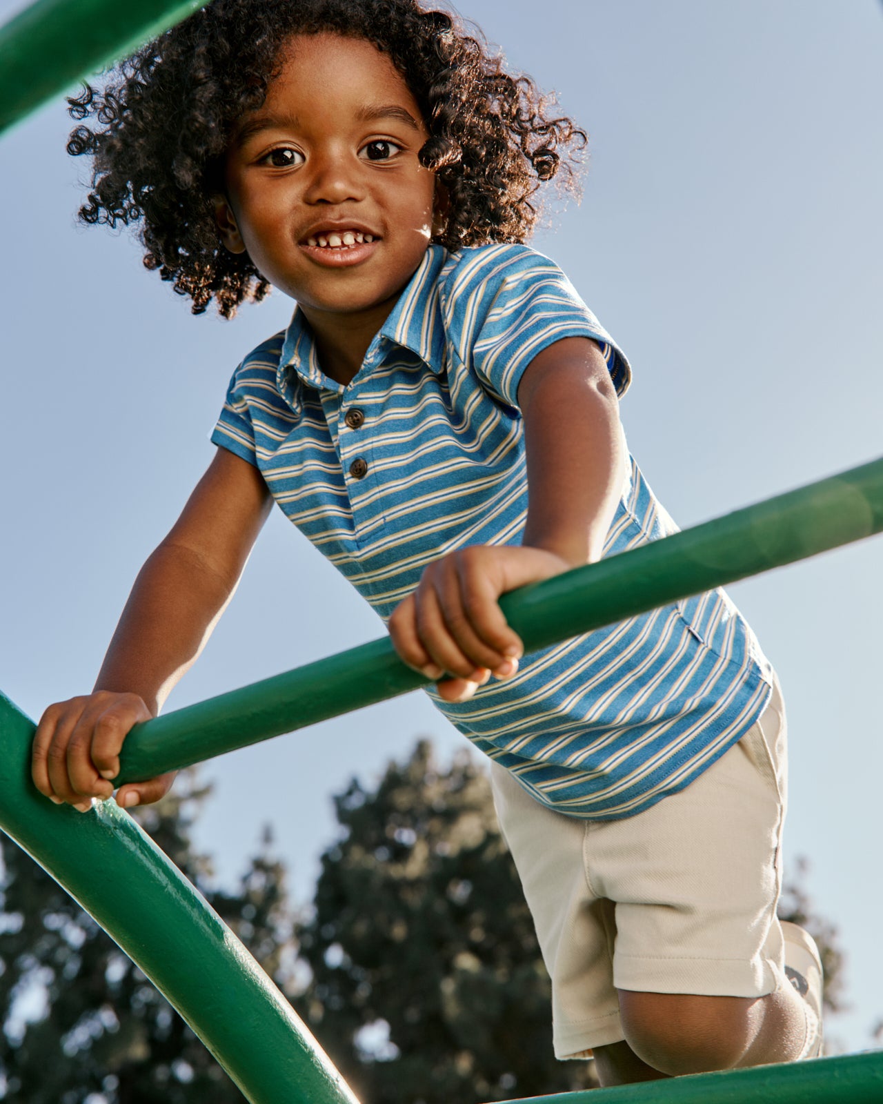 Boy wearing the Jay Blue Heather Stripes Polo Shirt on a playground