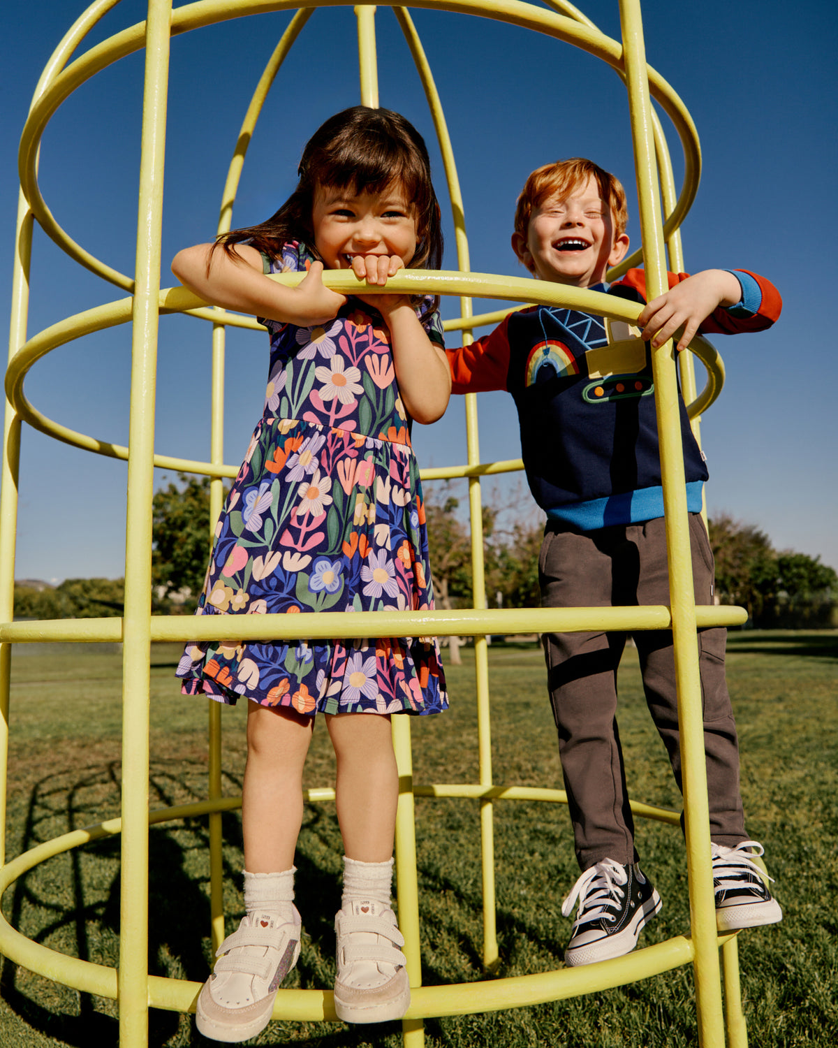 Two children wearing Back To School Play styles on a playscape 