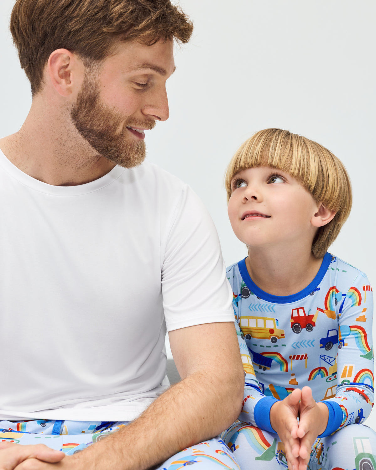 Father and child wearing matching Rainbow Trucks Bamboo Pajamas