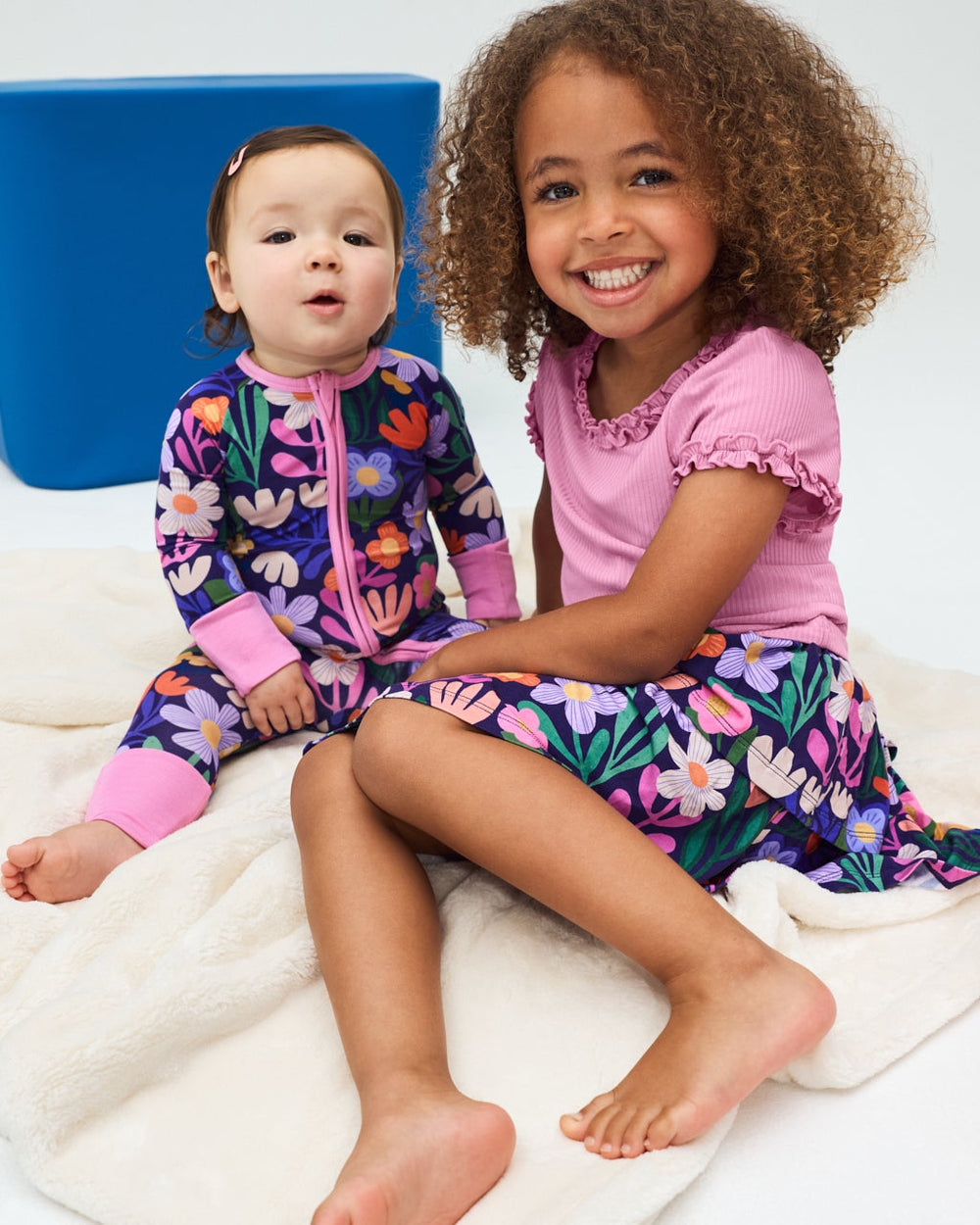 Two children wearing Wild Garden Sleep and Play styles