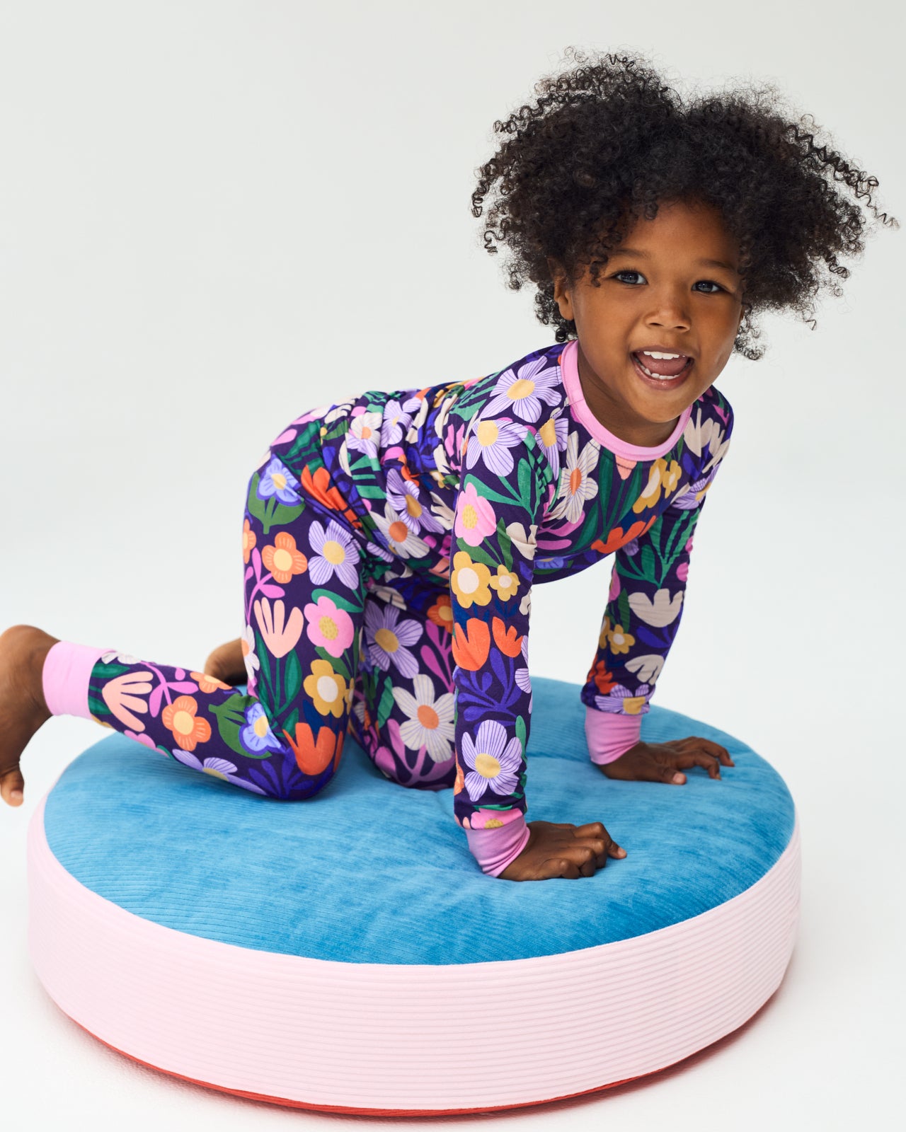 Girl sitting on a cushion wearing the Wild Garden Two-Piece Pajama Set
